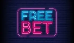 Neon sign reading "Free Bet" illuminated against a textured brick wall background